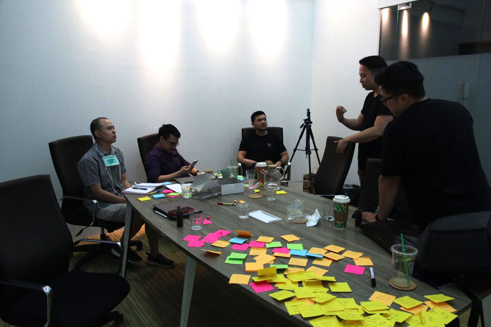 A strategy workshop with sticky notes spread across a meeting table