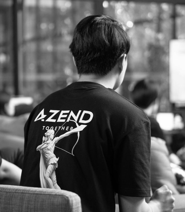 A team member from behind wearing an Azend Together T-shirt at a company session